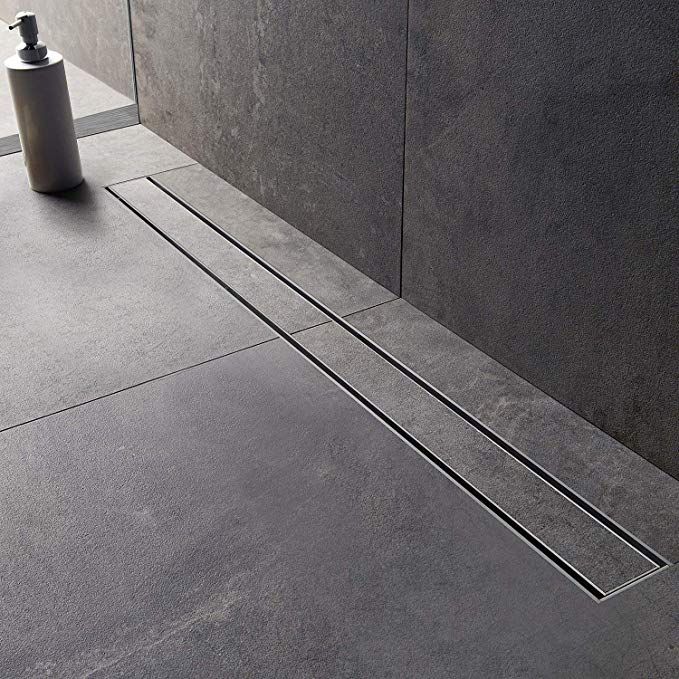 a modern textured grey bathroom with a lineal drainage system