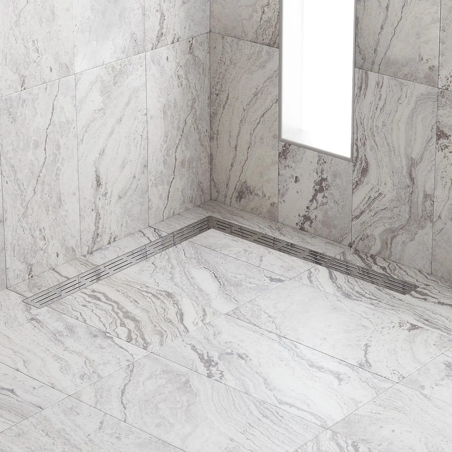 a white marble shower with a L shaped lineal drainage system