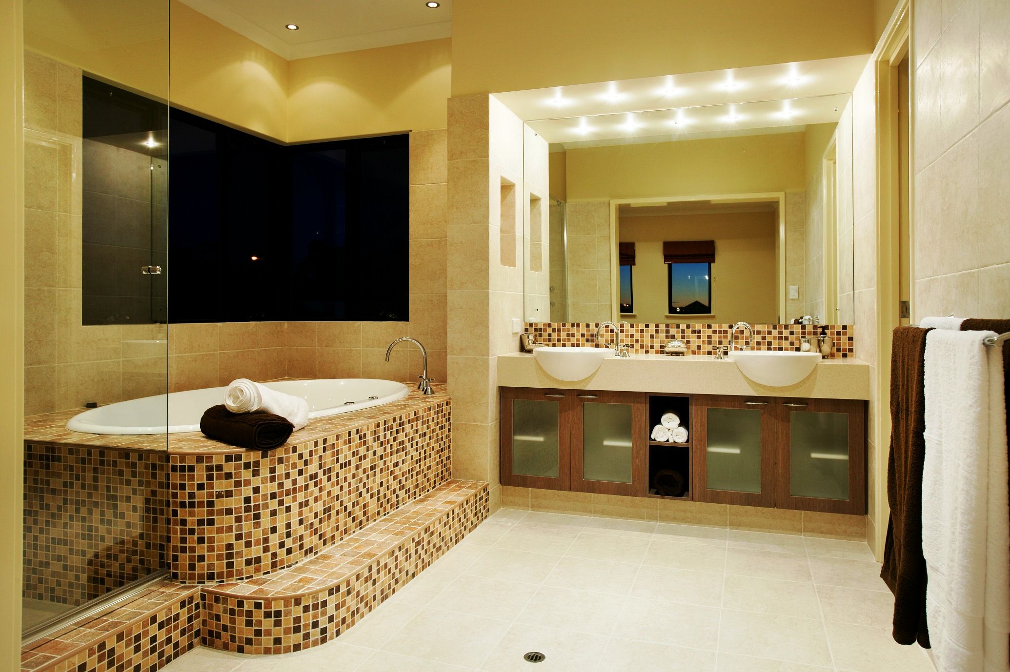 yellow marble bathroom with a white marble floor, a mirror and a spa with mosiac tiling