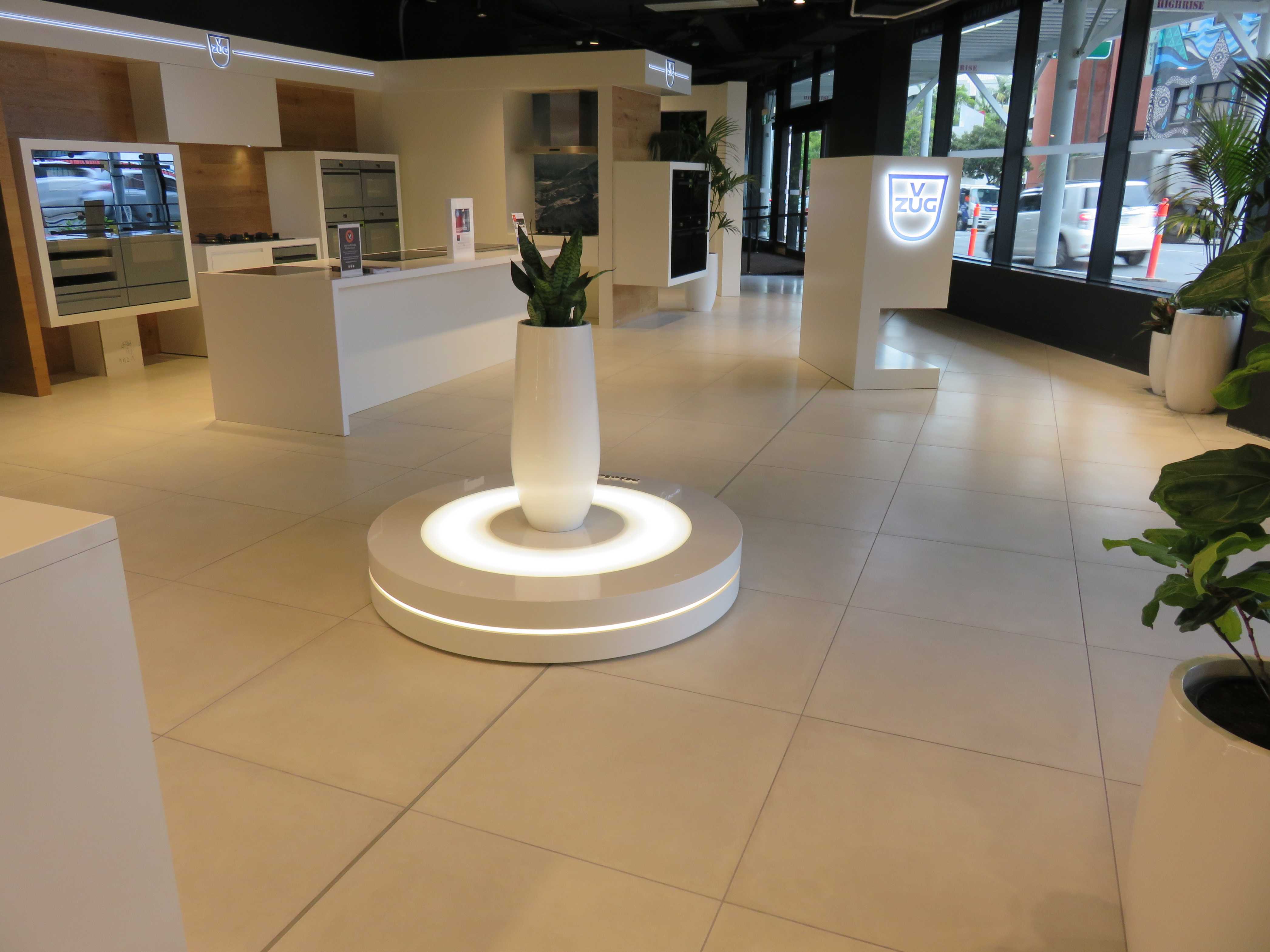 Kitchen showroom with ovens and white benchtops on white square tiling